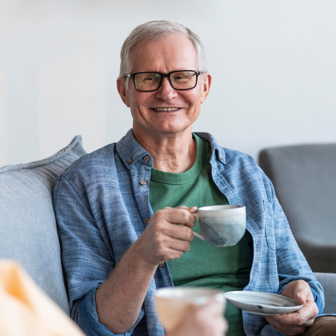 Older man smilling with tea cup